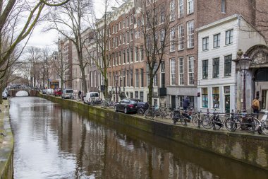 Amsterdam, Hollanda üzerinde 27 Mart 2016. Bahar akşam tipik kent görünümünde. Kanal ve Binalar bentleri tarihinde XVII-XVIII inşaatın Köprüsü