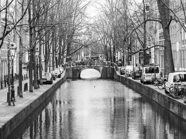 Amsterdam, Nizozemsko na 27 březen 2016. Typický městský pohled v jarní večer. Most přes kanál a budovy stavby Xvii a Xviii na nábřežích — Stock fotografie