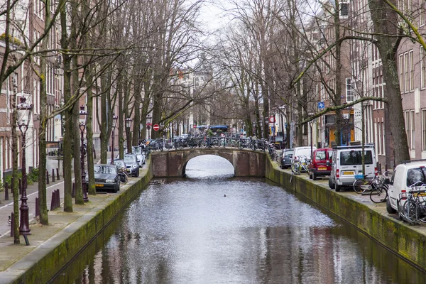 Amsterdam, Nizozemsko na 27 březen 2016. Typický městský pohled v jarní večer. Most přes kanál a budovy stavby Xvii a Xviii na nábřežích — Stock fotografie