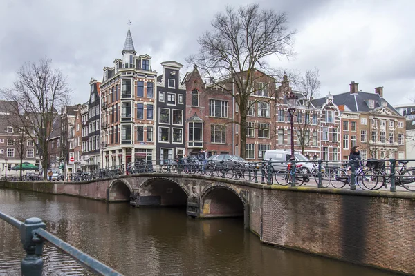 AMSTERDAM, PAYS-BAS, le 27 mars 2016. Vue urbaine typique dans la soirée de printemps. Le pont à travers le canal et les bâtiments de la construction XVII-XVIII sur les remblais — Photo