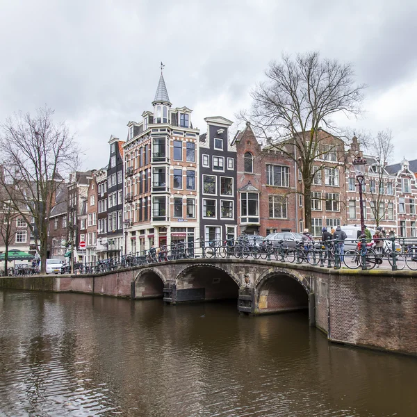 AMSTERDAM, PAYS-BAS, le 27 mars 2016. Vue urbaine typique dans la soirée de printemps. Le pont à travers le canal et les bâtiments de la construction XVII-XVIII sur les remblais — Photo