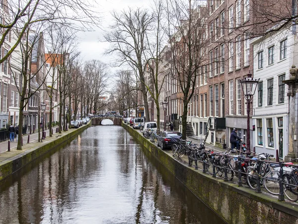 AMSTERDAM, PAÍSES BAJOS 29 DE MARZO DE 2016. Típica vista urbana en la tarde de primavera. El canal y los edificios de la construcción XVII-XVIII sobre terraplenes —  Fotos de Stock