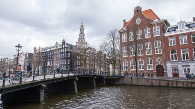 Amsterdam, Hollanda üzerinde 27 Mart 2016. Bahar akşam tipik kent görünümünde. Kanal ve Binalar bentleri tarihinde XVII-XVIII inşaatın Köprüsü