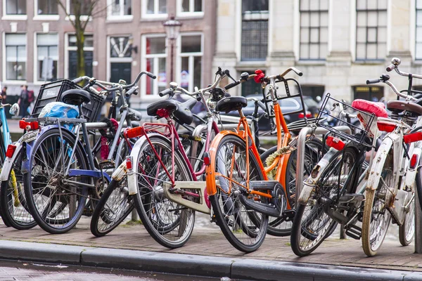 AMSTERDAM, NETHERLANDS on March 29, 2016. Типичный вид на город весной. Велосипеды стоят на набережной канала — стоковое фото