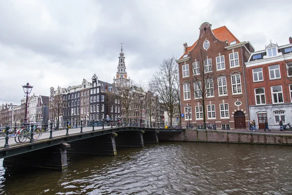 AMSTERDAM, PAYS-BAS, le 27 mars 2016. Vue urbaine typique dans la soirée de printemps. Le pont à travers le canal et les bâtiments de la construction XVII-XVIII sur les remblais — Photo