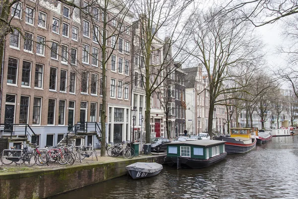 AMSTERDAM, NETHERLANDS on MARCH 27, 2016. Typical urban view. Houseboats near the bank — Stock Photo, Image