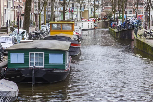 AMSTERDAM, NETHERLANDS on MARCH 27, 2016. Typical urban view. Houseboats near the bank — Stock Photo, Image