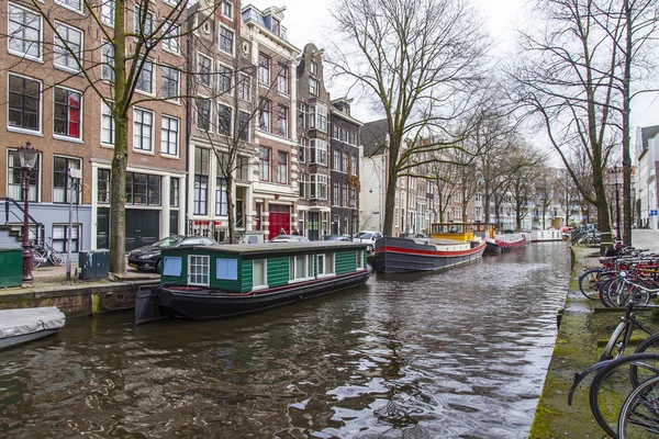 AMSTERDAM, PAÍSES BAJOS el 27 de marzo de 2016. Típica vista urbana. Casas flotantes cerca del banco — Foto de Stock