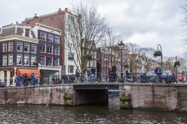 Amsterdam, Hollanda üzerinde 27 Mart 2016. Bahar akşam tipik kent görünümünde. Kanal ve Binalar bentleri tarihinde XVII-XVIII inşaatın Köprüsü