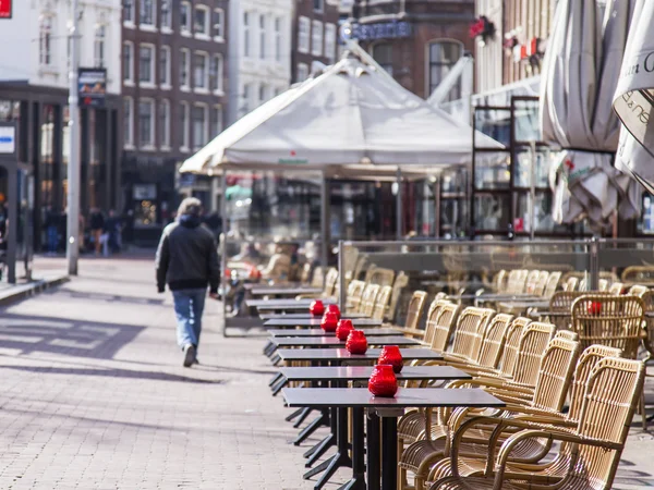 AMSTERDAM, PAÍSES BAJOS el 27 de marzo de 2016. Típica vista urbana en la mañana de primavera. Pequeñas mesas de café de verano bajo el cielo abierto —  Fotos de Stock