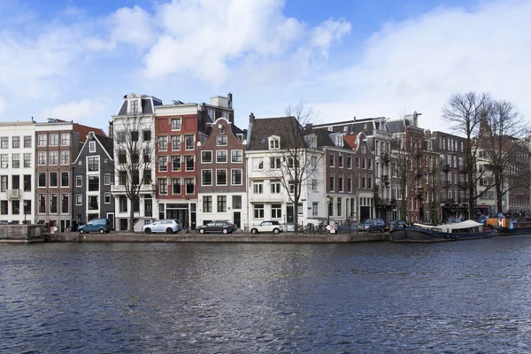 AMSTERDAM, PAÍSES BAJOS 29 DE MARZO DE 2016. Típica vista urbana en la tarde de primavera. Complejo arquitectónico de Amstel River Embankment — Foto de Stock