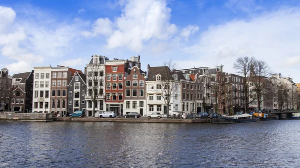 Amsterdam, Nizozemsko na 29 březnu 2016. Typický městský pohled jarního odpoledne. Architektonický komplex nábřeží řeky Amstel — Stock fotografie