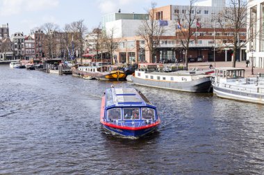 Amsterdam, Hollanda üzerinde 27 Mart 2016. Amstel Nehri yürüyüş gemi yüzer tipik kentsel görünümü