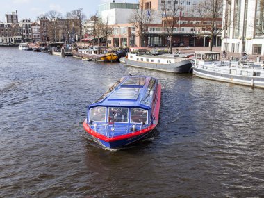 Amsterdam, Hollanda üzerinde 27 Mart 2016. Amstel Nehri yürüyüş gemi yüzer tipik kentsel görünümü