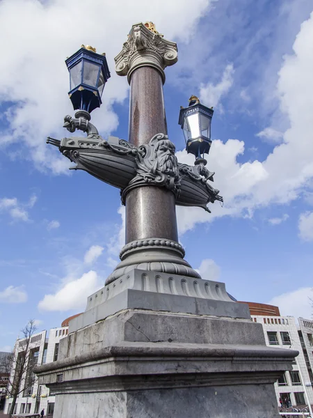 AMSTERDAM, PAESI BASSI il 29 marzo 2016. Tipica vista urbana nel pomeriggio primaverile. Una bella lampada elegante sul ponte attraverso il fiume Amstel — Foto Stock