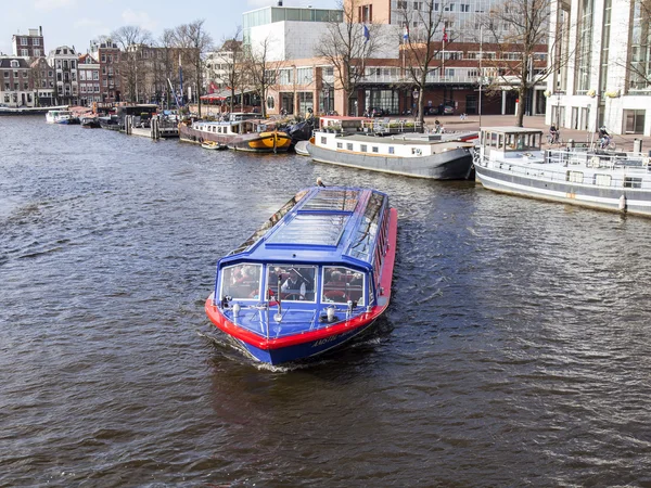 Amsterdam, Hollanda üzerinde 27 Mart 2016. Amstel Nehri yürüyüş gemi yüzer tipik kentsel görünümü