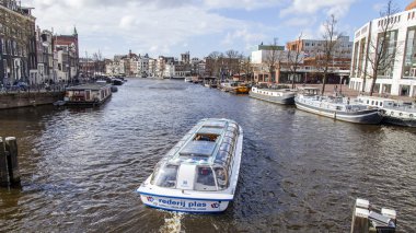 Amsterdam, Hollanda üzerinde 27 Mart 2016. Amstel Nehri yürüyüş gemi yüzer tipik kentsel görünümü
