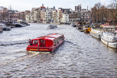 Amsterdam, Hollanda üzerinde 27 Mart 2016. Amstel Nehri yürüyüş gemi yüzer tipik kentsel görünümü