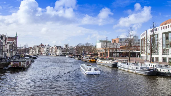 AMESTERDÃO, PAÍSES BAIXOS em 27 de março de 2016. A vista urbana típica o navio de passeio flutua abaixo do rio Amstel — Fotografia de Stock