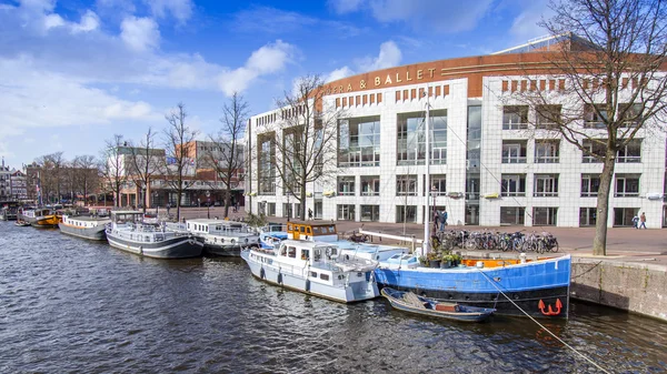 AMSTERDAM, PAESI BASSI il 31 marzo 2016. Tipica vista urbana in primavera. Il fiume Amstel e gli edifici della XVII-XVIII costruzione su argini. Houseboats vicino alla banca — Foto Stock