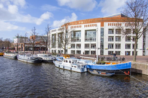 AMSTERDAM, PAESI BASSI il 29 marzo 2016. Tipica vista urbana nel pomeriggio primaverile. Amstel River Embankment. Teatro dell'Opera . — Foto Stock