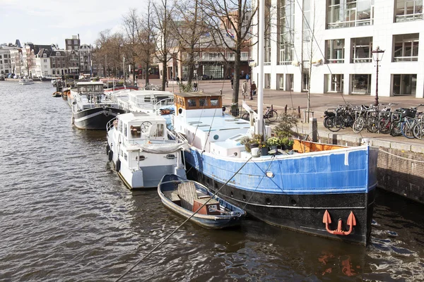AMSTERDAM, PAESI BASSI il 27 marzo 2016. Tipica vista urbana. Houseboats vicino alla banca — Foto Stock