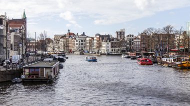 Amsterdam, Hollanda üzerinde 27 Mart 2016. Amstel Nehri yürüyüş gemi yüzer tipik kentsel görünümü