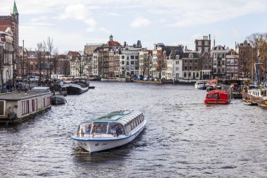 Amsterdam, Hollanda üzerinde 27 Mart 2016. Amstel Nehri yürüyüş gemi yüzer tipik kentsel görünümü