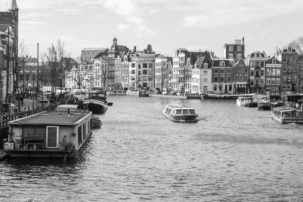 Amsterdam, Niederlande am 27. märz 2016. der typische städtebauliche anblick das wanderschiff schwimmt den fluss amstel hinunter — Stockfoto