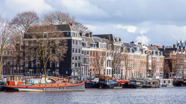 AMSTERDAM, NETHERLANDS on March 27, 2016. Типичный вид на город. Катера рядом с берегом Амстеля — стоковое фото
