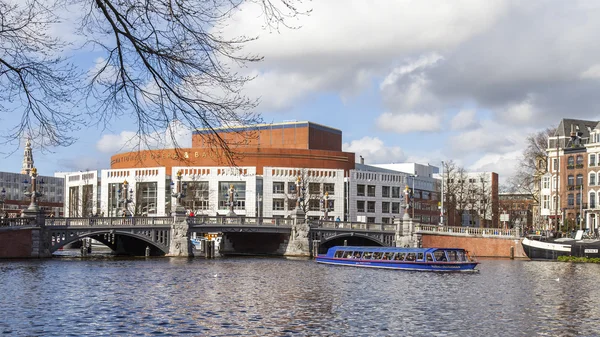 Amsterdam, Hollanda 29 Mart 2016 tarihinde. Bahar öğleden sonra tipik kentsel görünümü. Amstel Nehri Dolgusu. Opera tiyatrosu. — Stok fotoğraf