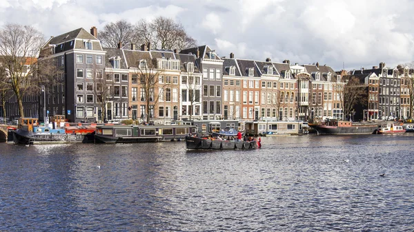 AMSTERDAM, NETHERLANDS on MARCH 29, 2016. Typical urban view in the spring afternoon. Amstel River Embankment. — Stock Photo, Image