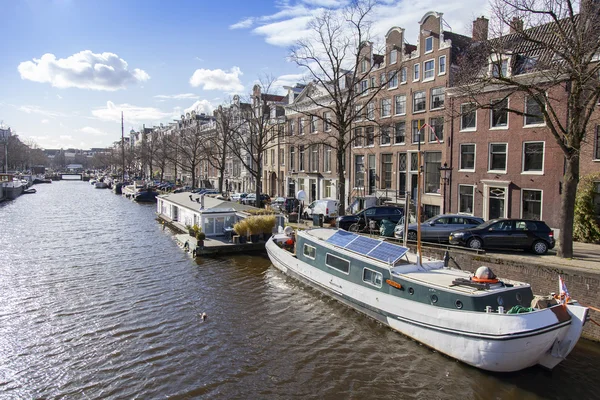 AMSTERDAM, NETHERLANDS on MARCH 27, 2016. Typical urban view. Houseboats near the bank of Amstel — Stock Photo, Image