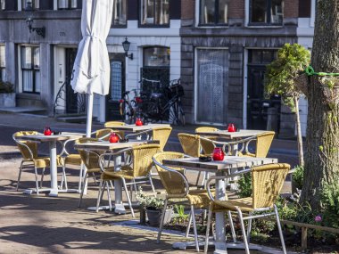 Amsterdam, Hollanda üzerinde 27 Mart 2016. Bahar sabahı tipik kent görünümünde. Açık havada yaz Kafe'nin küçük tablolar