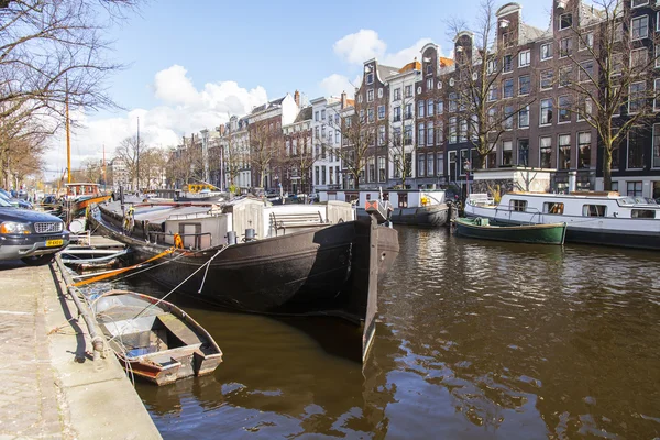 AMSTERDAM, PAÍSES BAJOS el 27 de marzo de 2016. Típica vista urbana. Casas flotantes cerca del banco — Foto de Stock