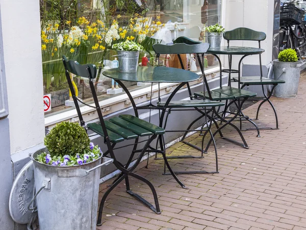 AMSTERDAM, PAÍSES BAJOS el 27 de marzo de 2016. Típica vista urbana en la mañana de primavera. Pequeñas mesas de café de verano bajo el cielo abierto — Foto de Stock