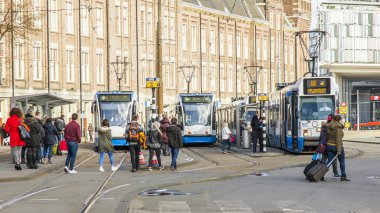 Amsterdam, Hollanda üzerinde 27 Mart 2016. Bahar akşam tipik kent görünümünde. Tramvay caddeden aşağı taşır