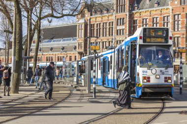 Amsterdam, Hollanda üzerinde 27 Mart 2016. Bahar akşam tipik kent görünümünde. Tramvay caddeden aşağı taşır