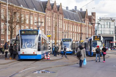 Amsterdam, Hollanda üzerinde 27 Mart 2016. Bahar akşam tipik kent görünümünde. Tramvay caddeden aşağı taşır