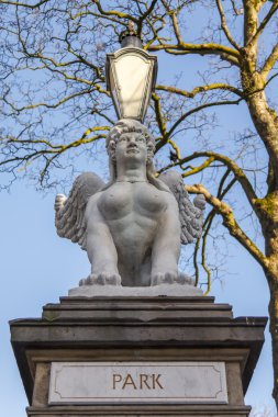 Amsterdam, Hollanda üzerinde 29 Mart 2016. Bahar öğleden sonra tipik kent görünümünde. Bir kentsel ortamda bir heykel. Kamu Parkı girişi