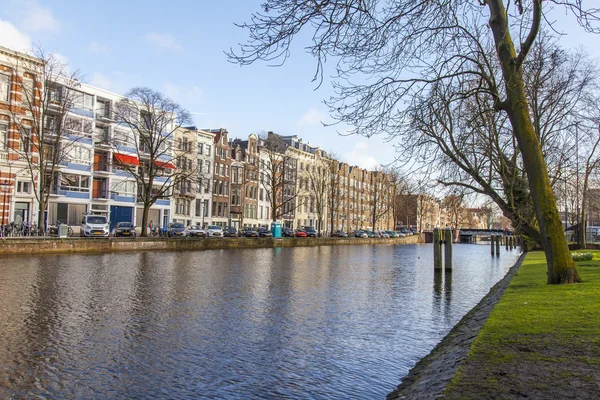 Amsterdam, Nizozemsko 30. března 2016. Typický městský výhled v jarním odpoledni. Budova stavby XVII-XVIII na nábřeží — Stock fotografie