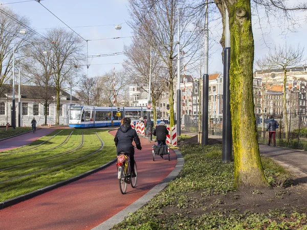 AMSTERDAM, NETHERLANDS on March 30, 2016. Типичный вид на город весной. Трамвай движется по улице. — стоковое фото