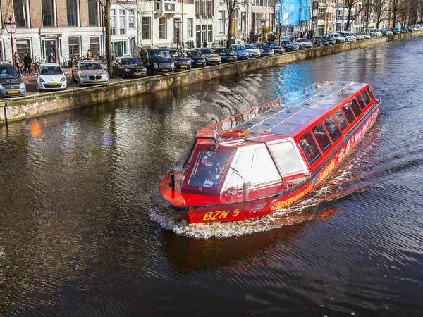 Amsterdam, Hollanda 30 Mart 2016 tarihinde. Tipik şehir manzarası. Yürüyen gemi kanalda yüzüyor.
