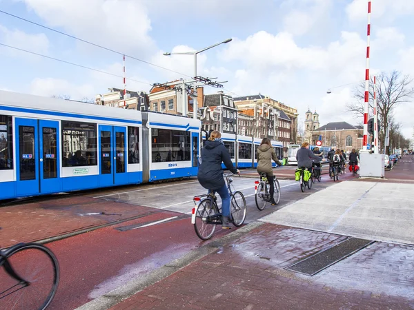 AMSTERDAM, PAÍSES BAJOS 30 DE MARZO DE 2016. Típica vista urbana en la tarde de primavera. El tranvía se mueve por la calle —  Fotos de Stock