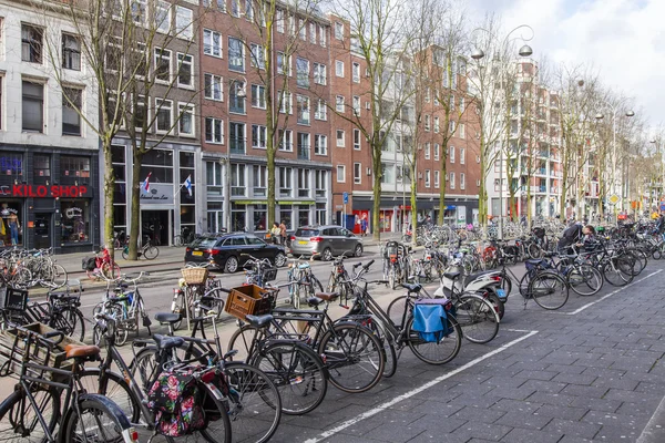 AMSTERDAM, PAÍSES BAJOS 30 DE MARZO DE 2016. Vista urbana. Las bicicletas están aparcadas en la calle de la ciudad —  Fotos de Stock