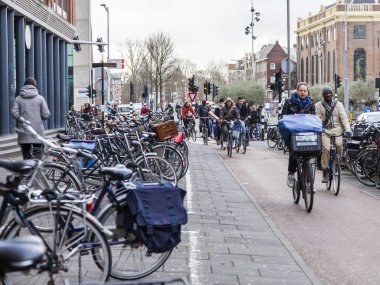 Amsterdam, Hollanda üzerinde 30 Mart 2016. Kentsel görünümü. Bisikletçiler caddeden aşağı git