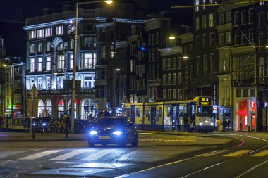 Amsterdam, Hollanda üzerinde 31 Mart 2016. Bahar akşam tipik kent görünümünde. Tramvay caddeden aşağı taşır