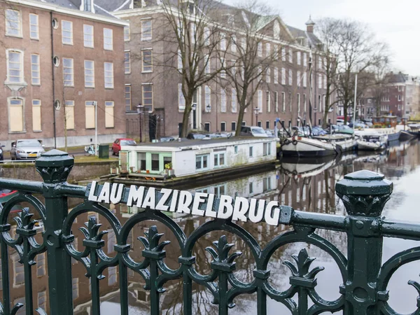 Amsterdam, Niederlande am 31. März 2016. typische Stadtansicht im Frühling. die Brücke durch den Kanal und die Gebäude der xvii-xviii-Konstruktion auf den Dämmen — Stockfoto