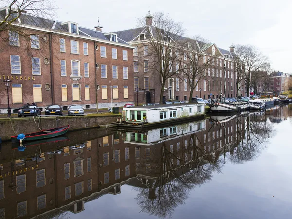 AMSTERDAM, PAÍSES BAJOS 31 DE MARZO DE 2016. Vista típica urbana en primavera. Edificios de la construcción XVII-XVIII sobre terraplenes. Casas flotantes cerca de banco —  Fotos de Stock