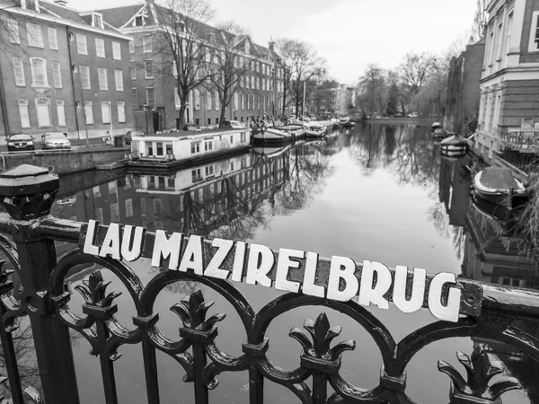 Amsterdam, Nizozemsko na 31 březnu 2016. Typický městský pohled na jaře. Most přes kanál a budovy stavby Xvii a Xviii na nábřežích — Stock fotografie